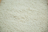 Close-up of plush, hand woven Moroccan shag rug with a soft, off-white texture.