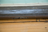 Bottom wooden dowel of vintage Africa map, showing 'RIVALED SERIES AFRICA' label and metal ring.