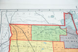 Vintage 1930s Minnesota map section: beige, green, orange; Kittson, Roseau counties, Manitoba.