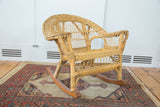 Vintage boho child's rocking chair, natural woven wicker with wooden rockers.