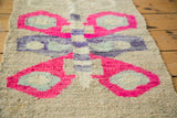 Textured pink, light blue, and purple butterfly wing on a retro American Kilim rug.