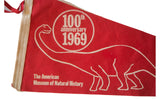Red felt flag with white dinosaur head, '100th anniversary 1969', and museum text.