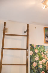 Vintage quilt ladder top with distressed light brown wood and sturdy metal bracket.