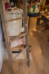 Tall early 20th century quilt ladder showcasing aged, industrial-style wood.