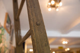 Vintage quilt ladder side rail with weathered wood grain and round peg detail.
