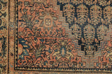 Dusty cochineal red boteh field, navy stepped border, worn edges of an antique Farahan Sarouk rug.