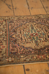 Close-up on the stepped medallion and low pile of a vintage Josan Sarouk rug in blush, blue, and brown.