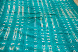 Intricate off-white patterns on a unique green hand-woven mudcloth textile.