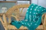 Supple green mudcloth textile showcasing intricate white hand-dyed patterns.