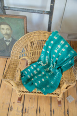 Collectible green African mudcloth with hand-woven texture and organic white patterns.
