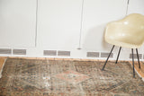 Textured detail of distressed antique Malayer rug with worn pile and visible holes.