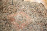 Antique Malayer rug's central medallion, distressed pile revealing terracotta, indigo, and sage floral motifs.
