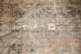 Distressed antique Malayer rug showing visible holes and exposed hand-knotted foundation.