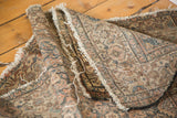 Distressed antique Malayer rug showing open ends, holes, and time-softened tones.
