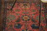 Vintage hand-knotted pile showcasing cranberry red field and cobalt floral motifs.
