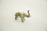 Vintage African miniature bronze elephant featuring prominent green patina and raised trunk.