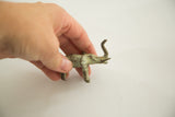 Vintage African bronze elephant sculpture held by hand, with aged green patina.