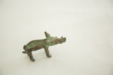 African bronze pig sculpture, its surface textured with natural green patina.