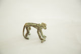 Vintage African bronze monkey casting with green patina, holding banana, 2 inches tall.