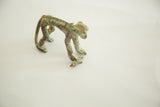Detail of the vintage African bronze monkey's textured green patina, holding its banana.