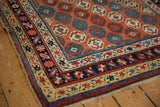 Antique Caucasian rug's distinct border bands with navy, cinnabar red, and saffron yellow motifs.