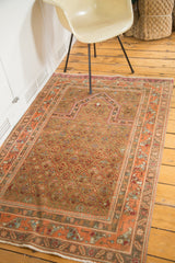 Vintage hand-knotted Indo Caucasian rug detail: peachy pink border, camel brown field, and fringe.