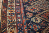 Intricate geometric motifs and repeating borders in indigo, brick red, and sand.