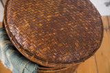 Intricate hand-woven texture of the vintage rattan basket lid in varied brown tones.