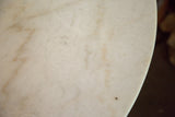 Close-up of vintage marble table top, showing light veining and subtle patina.