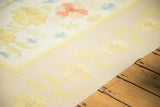 Vintage Dhurrie carpet corner with sunflower yellow, blush, and light blue scrolling florals.