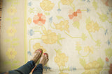 Vintage Dhurrie carpet with yellow and blush floral pattern, light border, and feet.