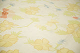 Vintage Dhurrie carpet's scrolling design in yellow, blush, light blue, and green.