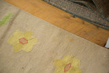 Playful yellow flower with terra cotta center on a beige vintage Dhurrie rug.