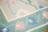 Vintage Dhurrie carpet: honeydew green border, rose blush and blue serrated floral motifs.