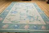 Vintage Dhurrie rug corner with honeydew green border, rose and blue floral motifs.