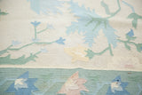 Textured flatweave of a vintage Dhurrie rug, with ivory, blue, and green floral motifs.