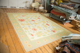 Playful vintage Dhurrie carpet showing large scrolling yellow and blush florals.