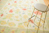 Vintage Dhurrie carpet border and large-scale yellow, blush, blue floral pattern.