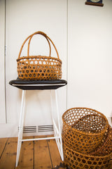 Two hand-woven vintage Japanese baskets with delicate hexagonal weave, stacked on the floor.