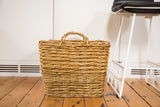 Square vintage wicker basket with tightly woven natural tan texture and braided handles.