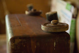 Textured dark brown wood and worn round knob of the vintage cedar chest.