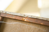 Back of antique miniature landscape canvas, showing aged wooden stretcher bar and visible wear.