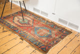 Antique Bakshaish rug runner's distressed geometric design in red, mint green, and ocean blue.