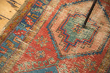 Distressed antique Bakshaish rug detail: vibrant mint green, ocean blue, red, and soft pink geometric pattern.