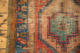 Distressed geometric Bakshaish rug with mint green, ocean blue, red patterns, secured edge.