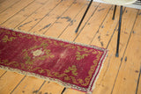 Antique Turkish Oushak rug mat: cinnabar red field, gold border, cloudband motifs, and visible wear.