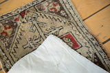 Lifted corner of a distressed antique Turkish Oushak rug, showing its linen mounting.