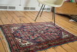 Angled view of vintage hand-knotted Tajabad rug, herati motif in indigo, rust, and ivory.