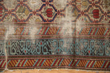 Heavy tatter revealing the fine weave and rare light blue border of an antique Marsali rug.