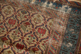 Finely woven lattice and rare blue and charcoal border on the tattered corner of an antique Marsali rug.
